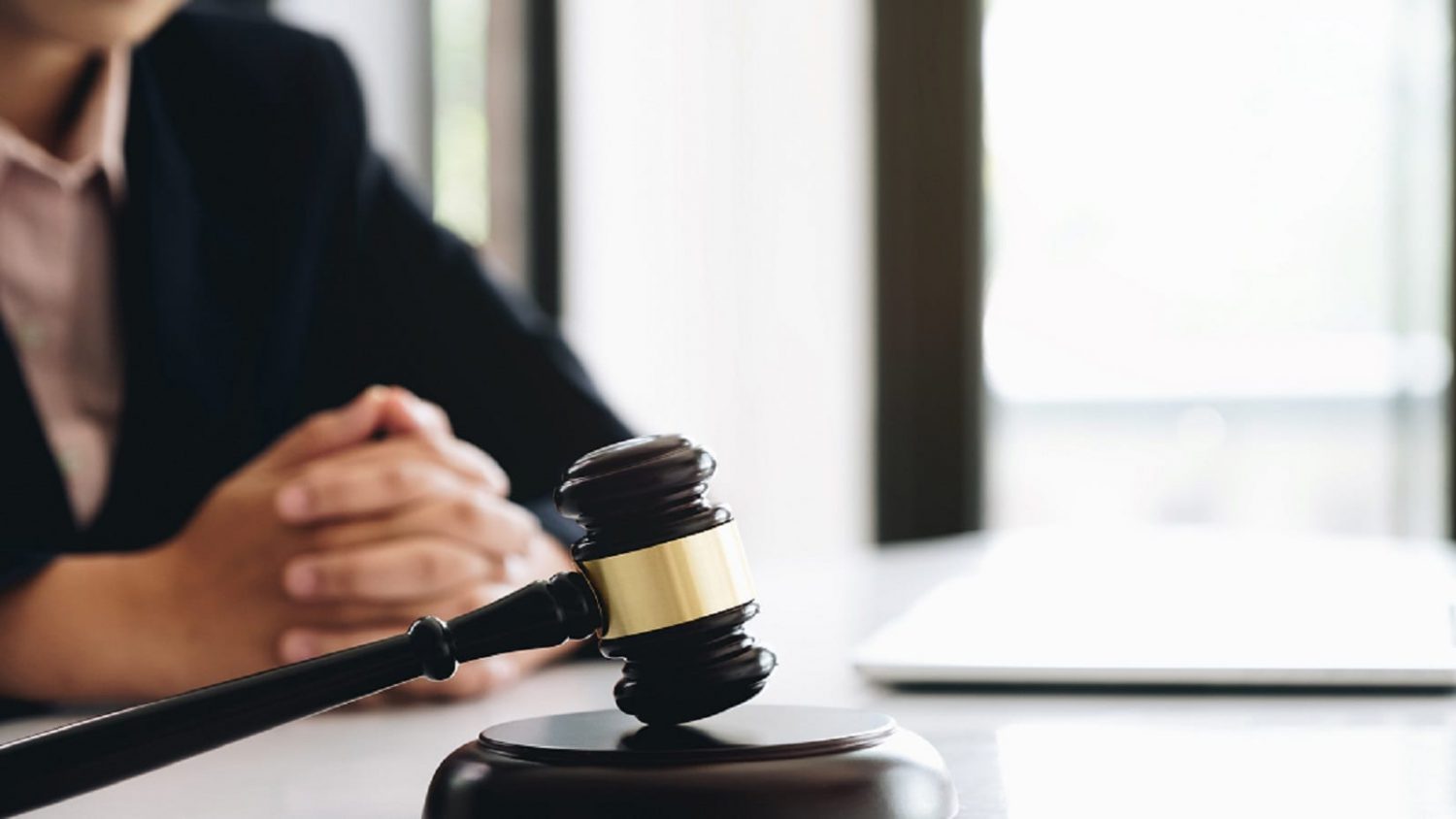 Lawyer Sitting Next To A Gavel Stock Photo