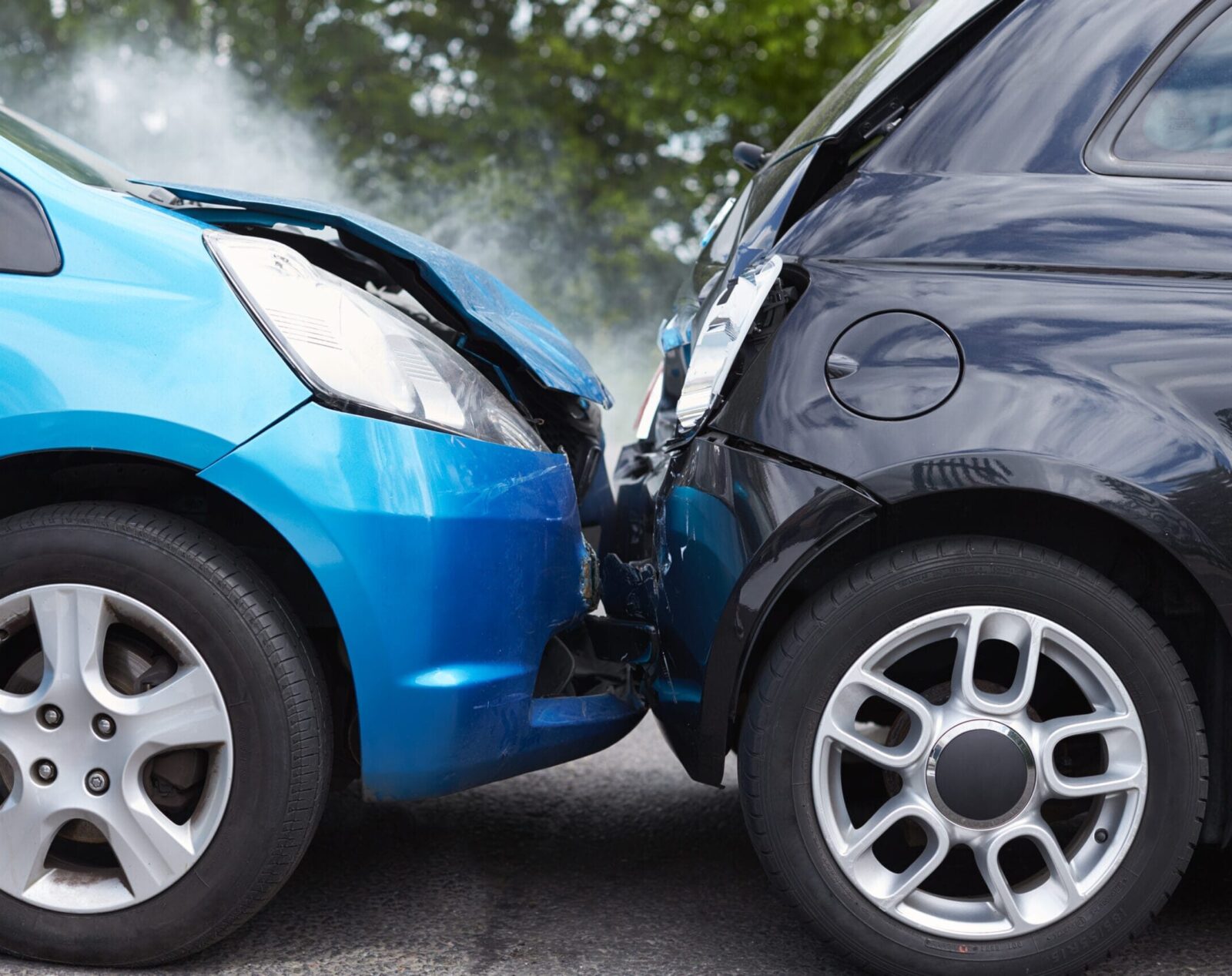 A blue car rear-ended another vehicle in a car accident. Both vehicles are badly damaged.